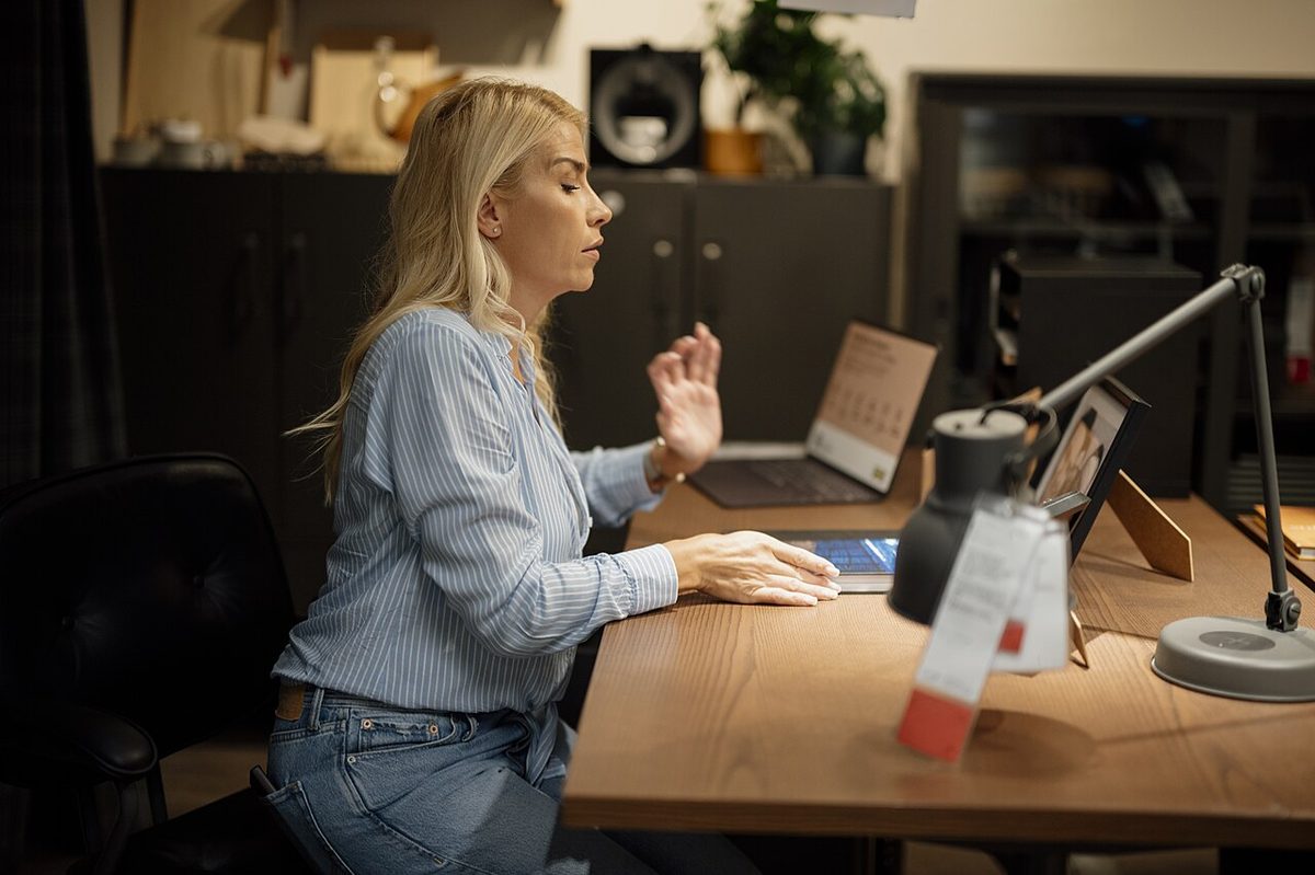 A person working at a laptop in a home office