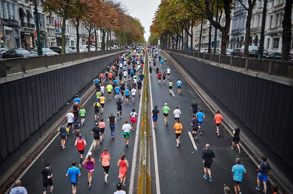 A large group of people running together during a city road race